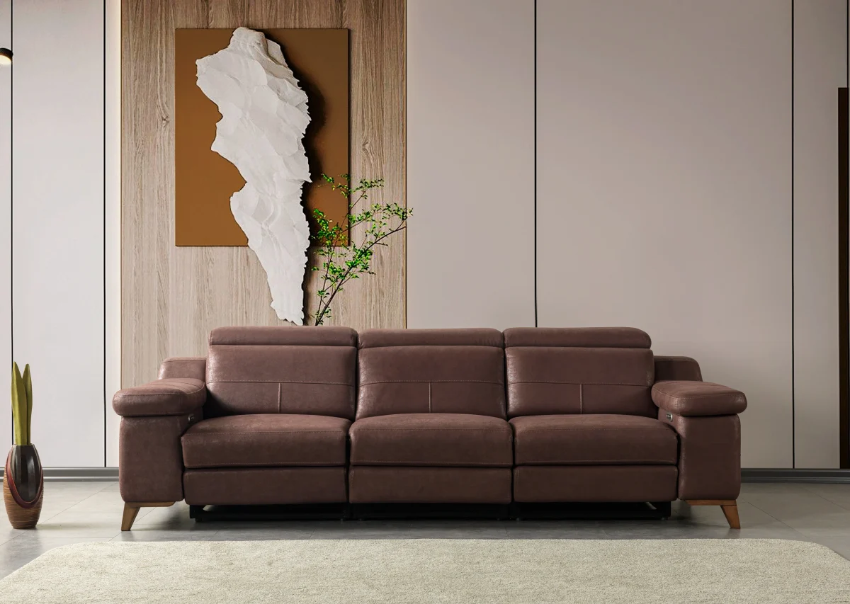 A modern multi-seater recliner sofa featuring adjustable headrests, extendable footrests, wide plush armrests, and a rich textured leatherette finish in a contemporary living room setting.