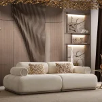 The Rumi Sofa in a sophisticated, contemporary interior with dark paneled walls and warm lighting, creating an atmosphere of deep harmony and artistic tranquility.