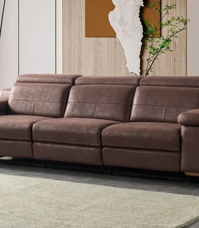 A modern multi-seater recliner sofa featuring adjustable headrests, extendable footrests, wide plush armrests, and a rich textured leatherette finish in a contemporary living room setting.