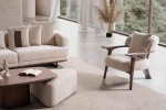 Sola Armchair with an exposed wooden frame, smooth wooden armrests, and a curved cushioned backrest