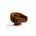 The Thalia Armchair offers a sophisticated seating experience, wrapped in rich, tactile fabric. Its base and seat create the perfect reading nook or decorative piece.