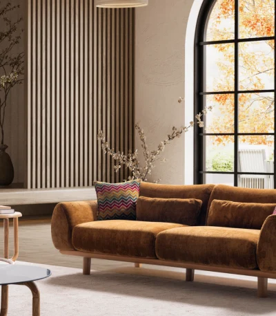 De Thalia-bank combineert organische, afgeronde lijnen met de rijke textuur van hoogwaardige stof. Een opvallend meubelstuk dat moderne warmte brengt in elke woonkamer.