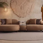 Tolia Chaise Corner Sofa – 3 Module (Wooden Middle Module) featuring soft beige seating units, a central wooden console table, and comfortable throw cushions in a warm interior design setup.
