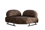 Tolia Corner Sofa - 4 Modules four-piece modular curved corner sofa in warm beige upholstery, featuring patterned accent pillows and a distinct corner module set against a modern wall.