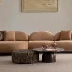 Tolia Chaise Corner Sofa - 3 Module three-piece modular curved sofa featuring an extended chaise end, warm beige upholstery, and plush decorative cushions.