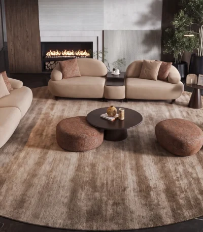 Tolia Sofa Set featuring a modular curved sofa, sculptural armchair, matching ottomans, and coffee tables arranged on a large round patterned rug in a modern living room.