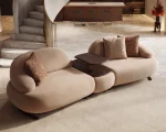 Tolia Sofa (With Mid. Wooden Module) modular beige sofa featuring organic curved seats and an integrated central wooden console table.