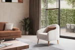 Troyas modern accent armchair with a curved backrest and textured ivory fabric, featuring an elegant sculptural design for a cozy living room corner – SofaTurkey.