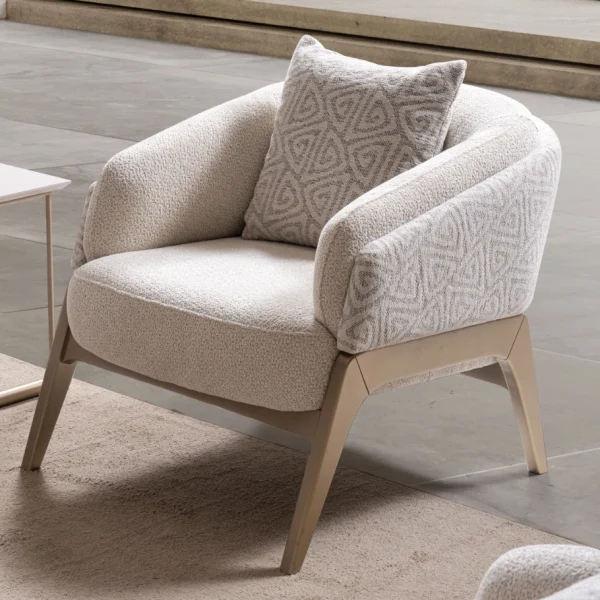 Velora Armchair featuring a curved barrel-style silhouette, patterned outer upholstery, and angled wooden legs.