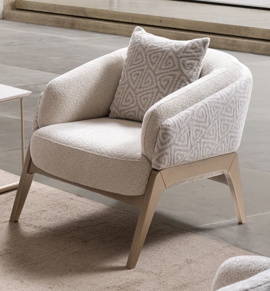 Velora-armchair 2 Velora Armchair featuring a curved barrel-style silhouette, patterned outer upholstery, and angled wooden legs.