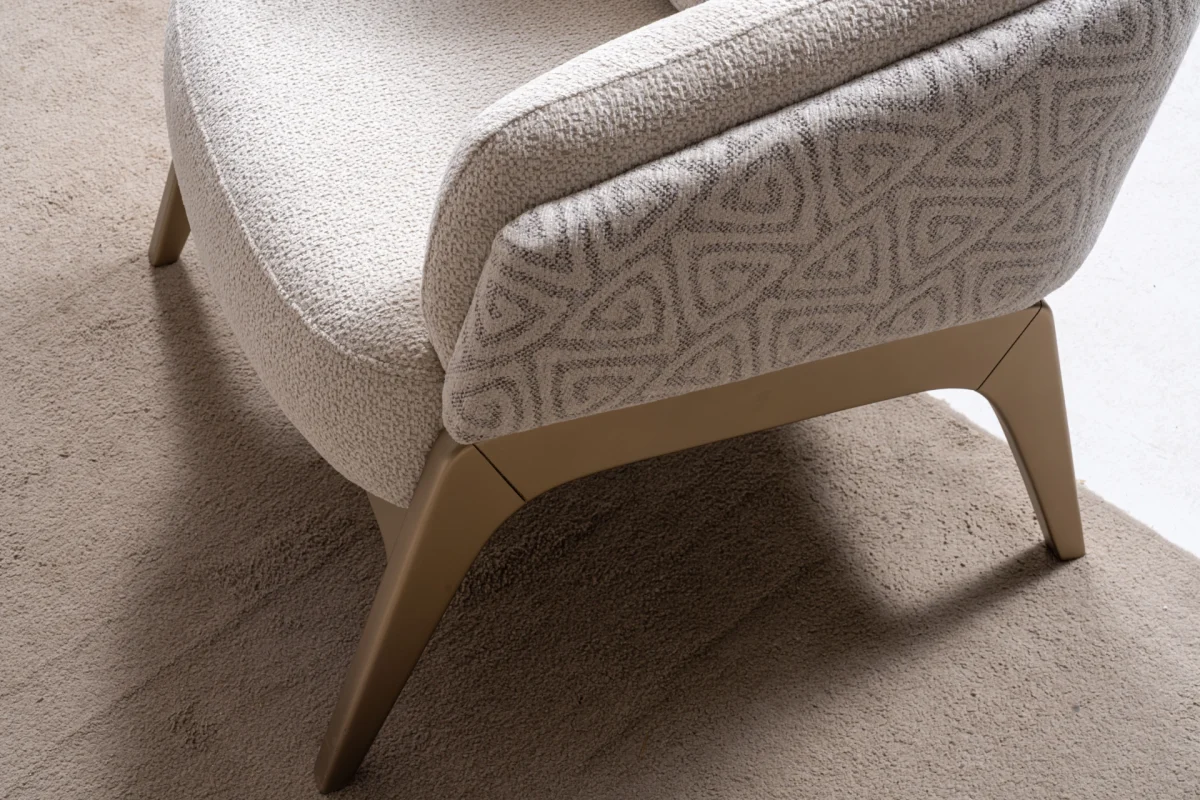Velora Armchair featuring a curved barrel-style silhouette, patterned outer upholstery, and angled wooden legs.