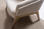 Velora Armchair featuring a curved barrel-style silhouette, patterned outer upholstery, and angled wooden legs.