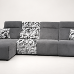 A modern sectional power recliner sofa featuring an integrated chaise lounge, patterned accent backrest and seat section, soft throw cushions, and smooth high-back plush cushioning set against a clean backdrop.