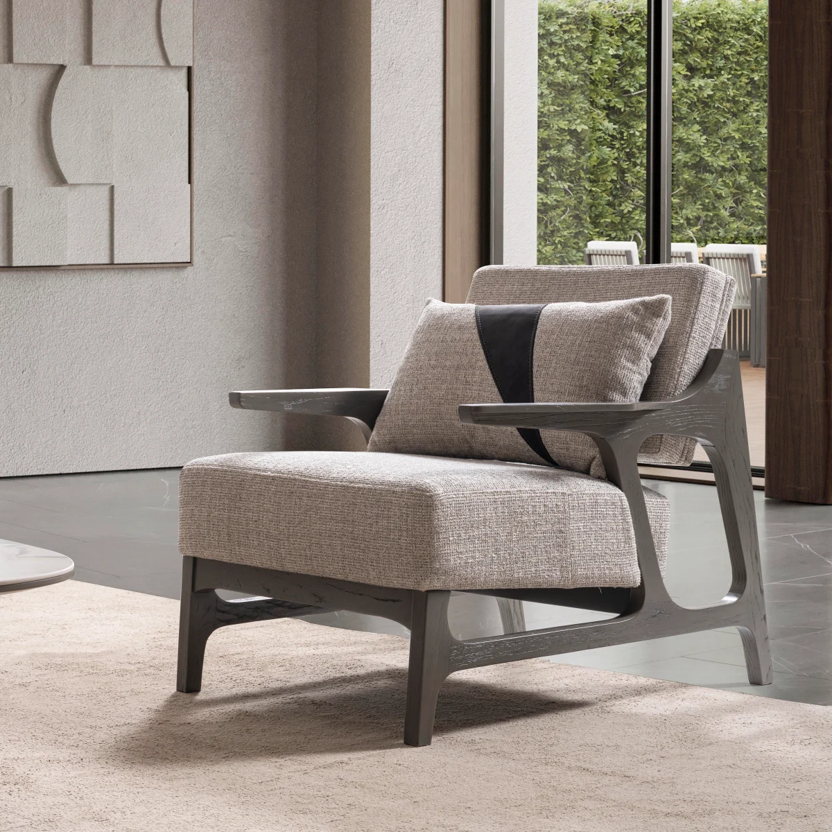 A contemporary Nova Armchair featuring an architectural open wooden frame, slim contoured armrests, a deep plush seat cushion, and a matching geometric accent pillow in a sunlit room setting.