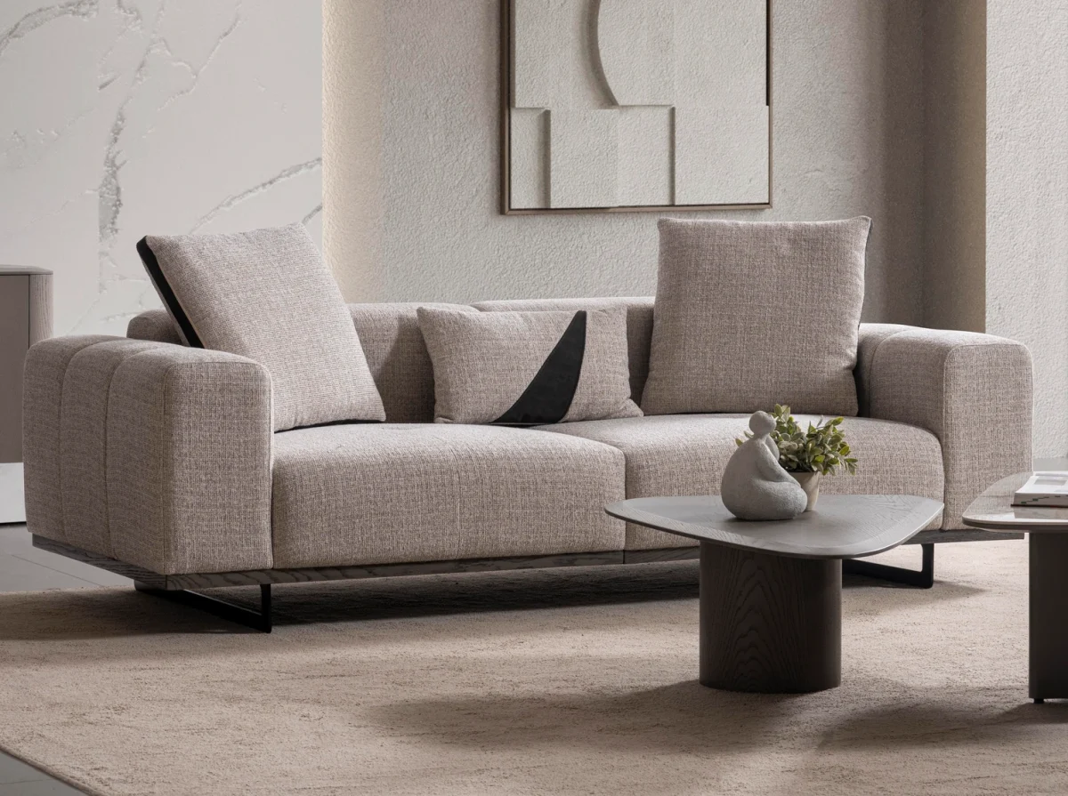 A modern textured fabric Nova Sofa featuring deep seating cushions, adjustable plush backrest pillows, channel-tufted wide armrests, and sleek low-profile metal legs in a minimalist room interior.