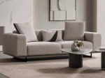 A modern textured fabric Nova Sofa featuring deep seating cushions, adjustable plush backrest pillows, channel-tufted wide armrests, and sleek low-profile metal legs in a minimalist room interior.